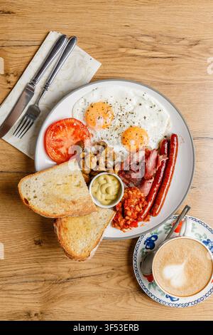 Englisches Frühstück auf einem Restauranttisch, mit Besteck und Kaffee. Isoliert. Professionelle Beleuchtung. Oberblick. Flachlage. Stockfoto