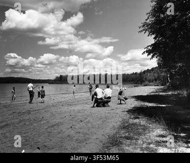 Badegäste haben Spaß am Strand im Anvil Lake Recreation Area, auf einem Foto aus der Mitte des 20. Jahrhunderts. Stockfoto