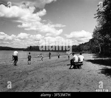 Badegäste haben Spaß am Strand im Anvil Lake Recreation Area, auf einem Foto aus der Mitte des 20. Jahrhunderts. Stockfoto