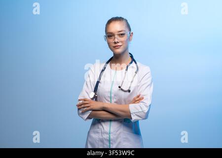 Medizinische Fachkraft steht mit verschränkten Armen Stockfoto
