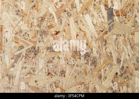 Nahaufnahme der Oberfläche einer komprimierten Holzspantafel. Abstrakte Textur von gepressten Holzspänen und Holzspänen, die im Bauwesen und in der Tischlerei verwendet werden. Stockfoto