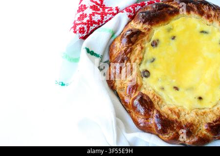 Traditionelles österliches Süßbrot gefüllt mit Hüttenkäse und Rosinen, in besticktes Handtuch gewickelt. Stockfoto für Back- und Feiertagskonzepte. Stockfoto