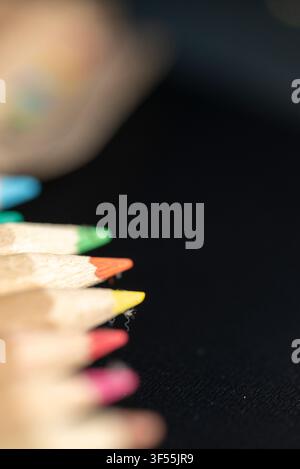 Reihe scharfer Farbstifte, die zur linken Seite zeigen und leeren Platz für Text lassen Stockfoto