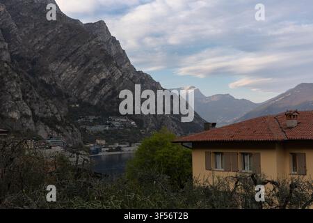 Abendansicht des Gardasees, eingerahmt von dramatischen Bergen und traditionellen italienischen Häusern in Limone sul Garda, Lombardei, Italien. Stockfoto