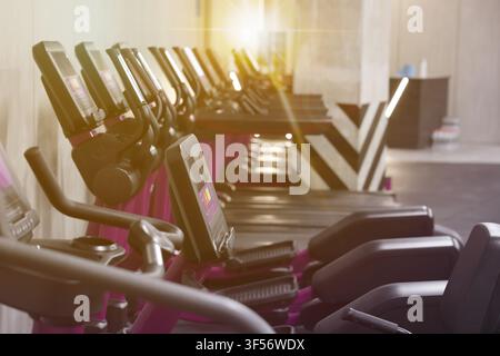 Cardio-Zone mit Fitnessbikes und Laufbändern in einem sonnendurchfluteten Fitnessstudio, selektive Fokussierung Stockfoto