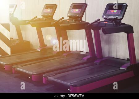 Cardio-Zone mit Laufbändern in einem sonnendurchfluteten Fitnessstudio, selektive Schärfe Stockfoto