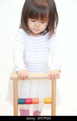 Japanisches Mädchen schiebt einen Wagen (2 Jahre alt) Stockfoto