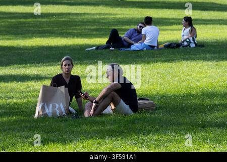 Zwei Frauen sitzen zusammen auf dem Gras auf dem Boston Common in Boston, Massachusetts. Stockfoto