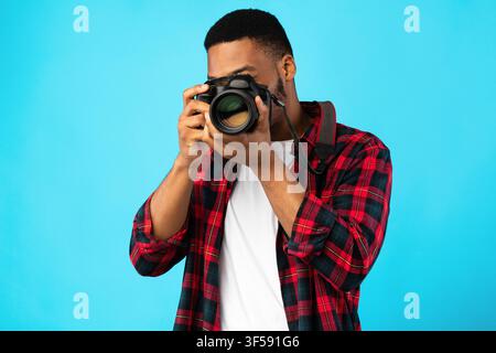Afroamerikanischer Fotograf, Der Ein Foto Auf Blauem Hintergrund Macht Stockfoto