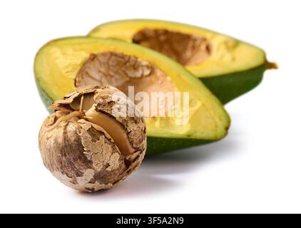 gerissener Avocado-Kern und zwei Hälften isoliert auf weißem Hintergrund, brauner Schalenabstand und frisches grünes Fruchtfleisch in Nahaufnahme Stockfoto