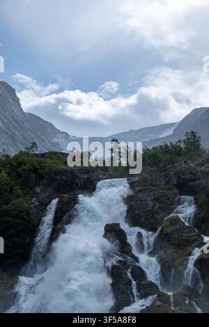 Mächtige Gletscher Schmelzwasser stürzen über Felsen am Briksdalsbreen, Norwegen, ideal für Wildnis- und Klimawandel-Themen. Stockfoto