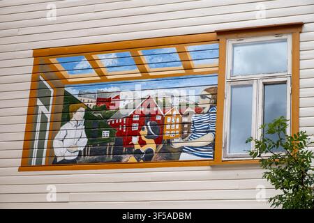 Lebendige bemalte Wandmalerei auf einer weißen Holzwand in Trondheim, die eine Kaffeeszenen mit farbenfrohen norwegischen Häusern darstellt, ideal für Reise- und Kulturredaktionen Stockfoto