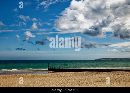 Eine Aussicht vom Strand von Bournemouth über eine weite blaugrüne See zu den Klippen der Isle of Purbeck, Dorset, England. Stockfoto