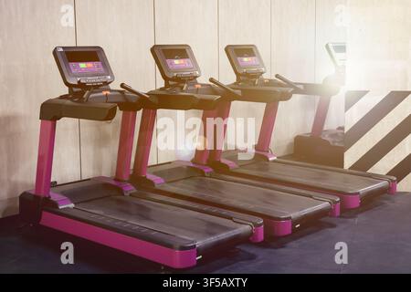 Cardio-Zone mit Laufbändern in einem sonnendurchfluteten Fitnessstudio Stockfoto