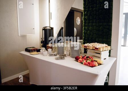 Catering-Buffet mit frischen Früchten und Vorspeisen in einem modernen Bürokonferenzraum. Firmen-Catering, Geschäftsessen, Büroparty, Event-Cateringservice, gesunde Snacks, Kaffeepause während der Konferenz Stockfoto