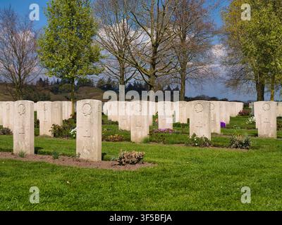Groesbeek, Niederlande - 14. Apr 2026: Reihen weißer Militärgrabsteine zwischen grünen Rasenflächen und Frühlingsbäumen auf dem kanadischen Kriegsfriedhof Groesbeek, Niederlande Stockfoto