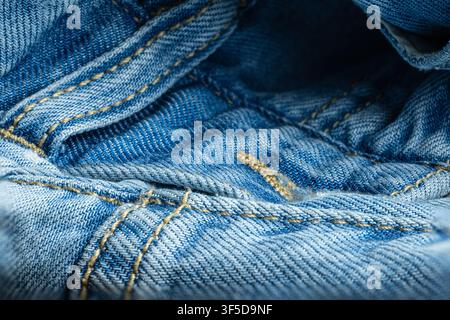 Blaues Denimgewebe, das Details der Nähte und der Textur zeigt Stockfoto