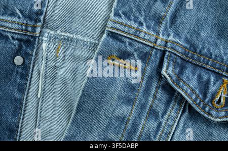 Nahaufnahme von blauem Denimstoff mit sichtbarer Textur, Nähten und Knopflöchern Stockfoto