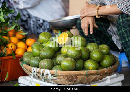 Reife frische grüne Mandarinen, exotische Früchte in einem Korb, zur Verkaufsausstellung auf einem Straßenfoodmarkt. Stockfoto