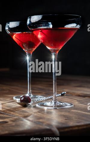 Zwei Whiskey-Manhattans serviert mit einer Kirsche auf einem rustikalen Holzgrund Stockfoto