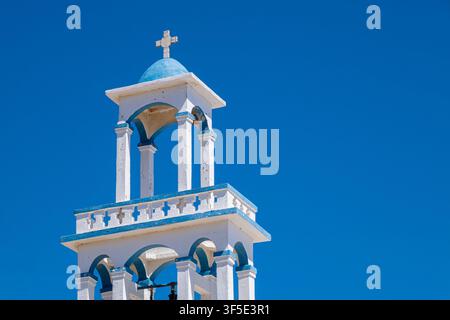 Glockenturm einer Kirche in Andros mit gewölbten Öffnungen und Kreuzornament, Andros, Griechenland Stockfoto