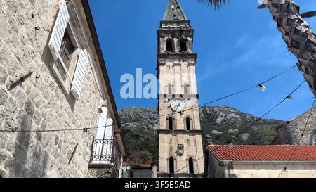 PERAST, MONTENEGRO - 15. MAI 2024: Niedrige Blickwinkelaufnahme des historischen steinernen Glockenturms der Kirche Saint Nicholas in Perast, Montenegro. Stockfoto