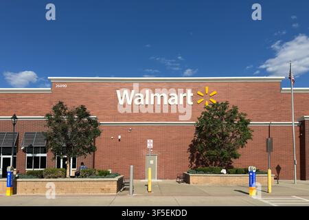 Novi, Michigan, USA - 23. Jul 2026: Vorderansicht eines modernen Walmart-Einzelhandelsgeschäfts mit roter Backsteinarchitektur, Schaufenster-Markisen und einem strahlend blauen Himmel. Stockfoto