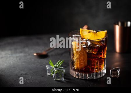 Frisch zubereitetes Cuba Libre Cocktail mit braunem Rum, Cola und Zitrone auf Holzhintergrund Stockfoto