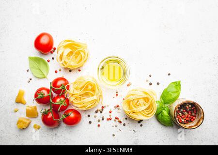 Hintergrund Pasta. Verschiedene Arten von trockener Pasta mit Gemüse und Kräutern auf weißem Hintergrund. Freier Platz für Text. Draufsicht Stockfoto