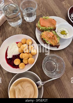 Gesunder Brunch mit geräuchertem Lachs-Avocado-Toast, Joghurt und Kaffee Stockfoto