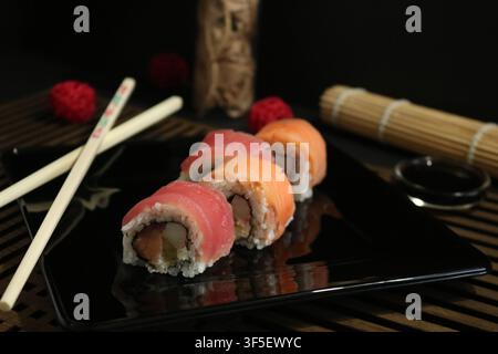 Frisches und leckeres Sushi japanisches Essen, Sushi-Rollen-Set auf dunklem Hintergrund serviert. Stockfoto