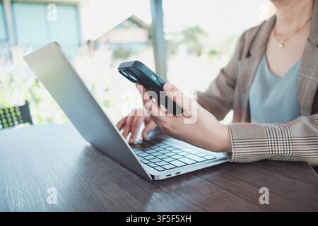 Nahaufnahme weiblicher Hände, die Smartphones zum Online-Shopping nutzen, Freelancer, der aus einem Café aus remote arbeitet. Kauf im Internet, E-Commerce-E-Banking-Dienst. Stockfoto