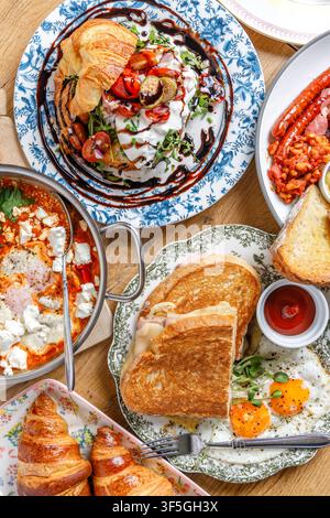 Verschiedene Gourmet-Frühstücks- und Brunchgerichte auf einem Holztisch Stockfoto