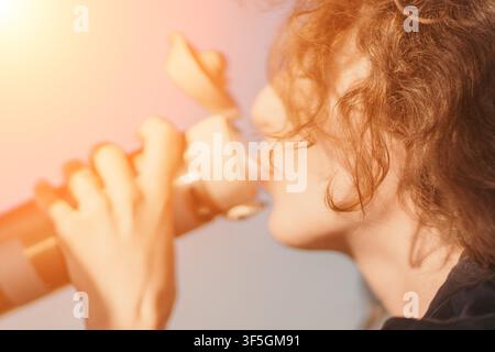 Frau, Hydrierung, Fitness, trinkt aus einer wiederverwendbaren Wasserflasche in Profilansicht mit Fokus auf Gesundheit und Wohlbefinden bei natürlichem Sonnenlicht Stockfoto