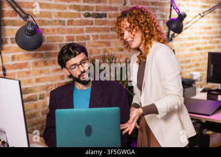 Kollegen arbeiten gemeinsam an einem Laptop in einem modernen Büro Stockfoto