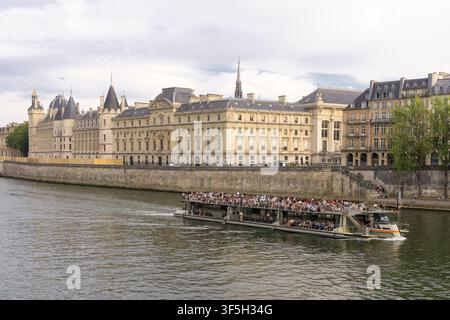 Conciergerie und Palais de Justice mit Sightseeing-Kreuzfahrtschiff auf der Seine, Paris, Frankreich. Stockfoto