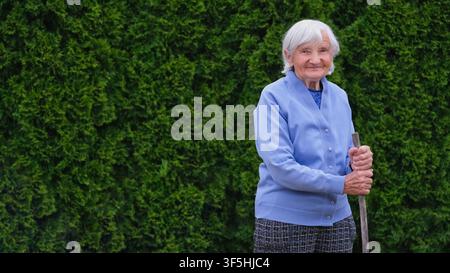 Ältere Frau mit Gehstock im Freien Stockfoto