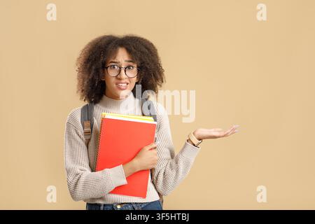 Negative menschliche Emotionen, unangenehme oder falsche Wahl. Bezweifelte afroamerikanische Frau in Brille und Notizblock zeigt die Hand auf Freiraum Stockfoto