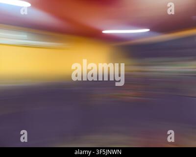Verwischen Sie das unscharfe Bild des Gangs im Supermarkt mit leichtem Bokeh. Verschwommenes abstraktes Bild des Hintergrunds eines Einkaufszentrums. Stockfoto