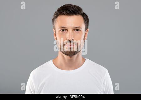 Porträt von schönen bärtigen Mann auf grauem Hintergrund Stockfoto