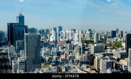 Weite Stadtsilhouette des Tokyoter Bezirks Minato mit modernen Wolkenkratzern, dichten Stadtblöcken und einem klaren blauen Himmel, aufgenommen von einem erhöhten Blickwinkel in d Stockfoto