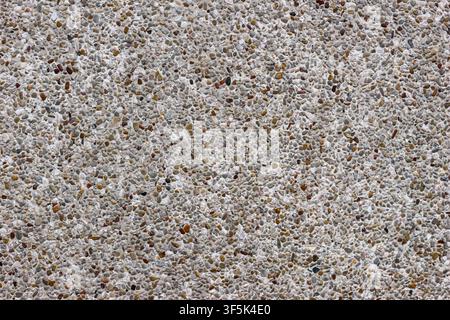 Außenwand aus Terrazzo mit feinem Kiesgranulat, das in Zement eingebettet ist, und zeigt eine langlebige architektonische Textur und natürliche Materialdetails. Stockfoto