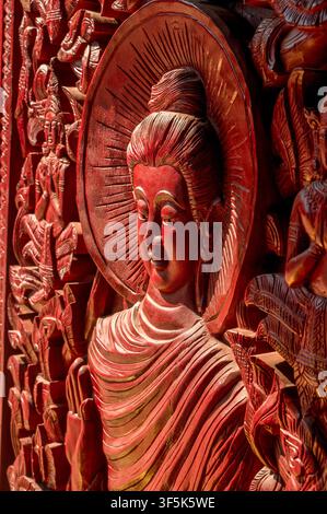 Nahaufnahme einer reich verziertem hölzernen Buddha-Statue mit kunstvollen Blumendetails im Wat Si Muang in Vientiane, Laos, die buddhistische Kunst, Hingabe, a Stockfoto