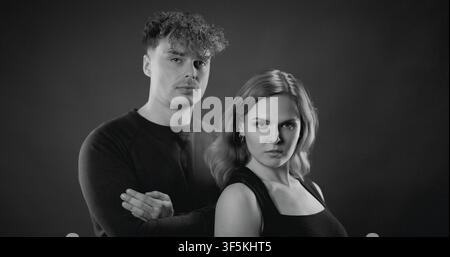 Junges Paar schaut direkt in die Kamera und zeigt einen ernsten und selbstbewussten Ausdruck Stockfoto