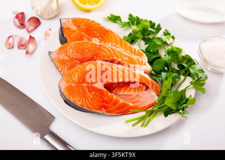 Rohe Lachssteaks auf dem Teller, auf weißem Hintergrund Stockfoto