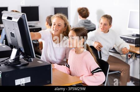 Porträt weiblicher und männlicher Schüler, die im Klassenzimmer am Computer arbeiten Stockfoto