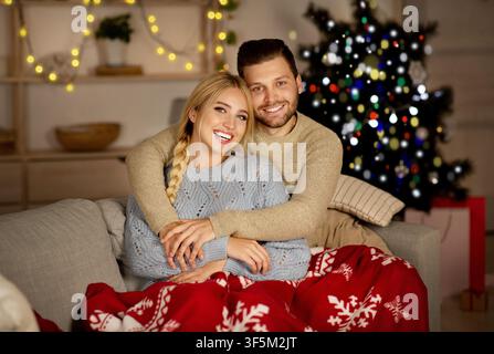 Lächelnd junge Familie Bonding auf Couch im dekorierten Wohnzimmer Stockfoto