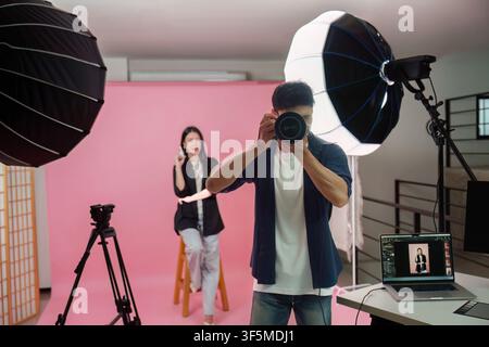 Fotograf macht Fotos von einem Model im Fotostudio Stockfoto