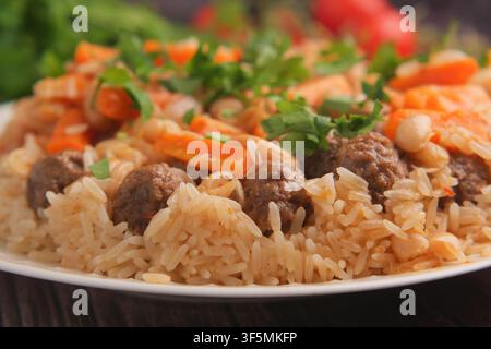 Rindfleisch-Fleischbällchen und Reis, serviert mit Gemüse auf einem Teller Stockfoto