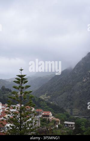 Das Dorf Argiroupoli auf Kreta, umgeben von üppigen Berglandschaften, traditionellen Häusern mit roten Dächern und nebelbedeckten Hügeln. Stockfoto